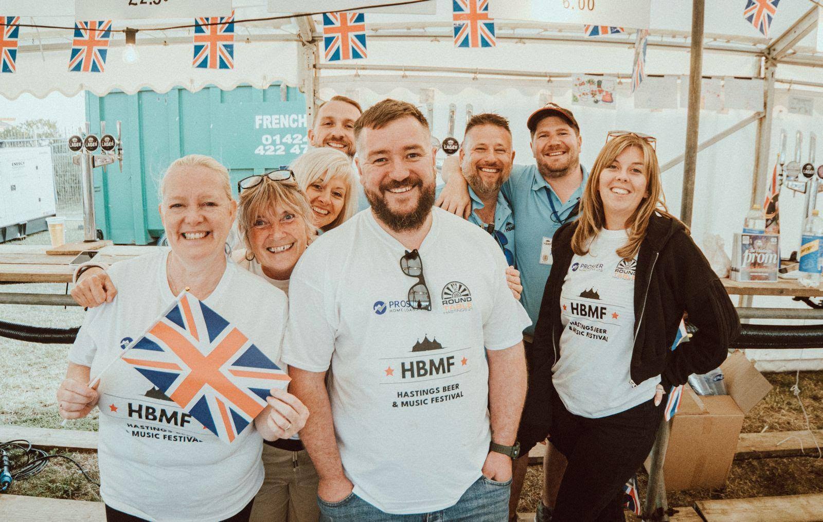 HBMF volunteers smiling together under the festival marquee