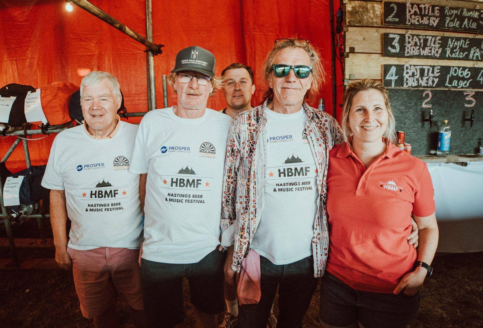 HBMF bar volunteers posing behind the beer taps